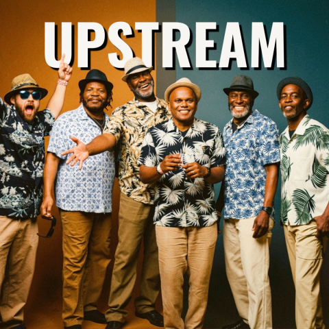 A group of six people standing side‑by‑side in front of a background split vertically between warm brown and teal colors. All six are wearing patterned button‑up shirts with leaf or geometric designs, light‑colored pants, and various hats. Some individuals have sunglasses or accessories. They are posed casually, with some extending an arm or making a gesture. Large white text at the top reads “UPSTREAM.”